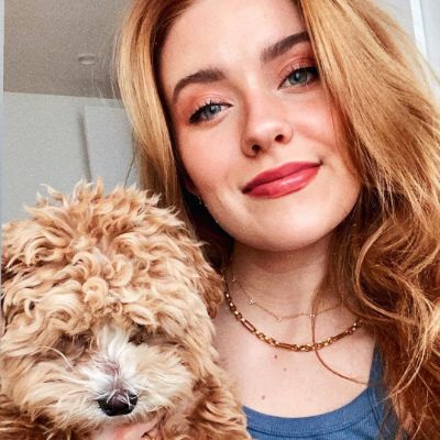 Kennedy McMann posing for a photo shoot while holding her dog, Otis in hand. 